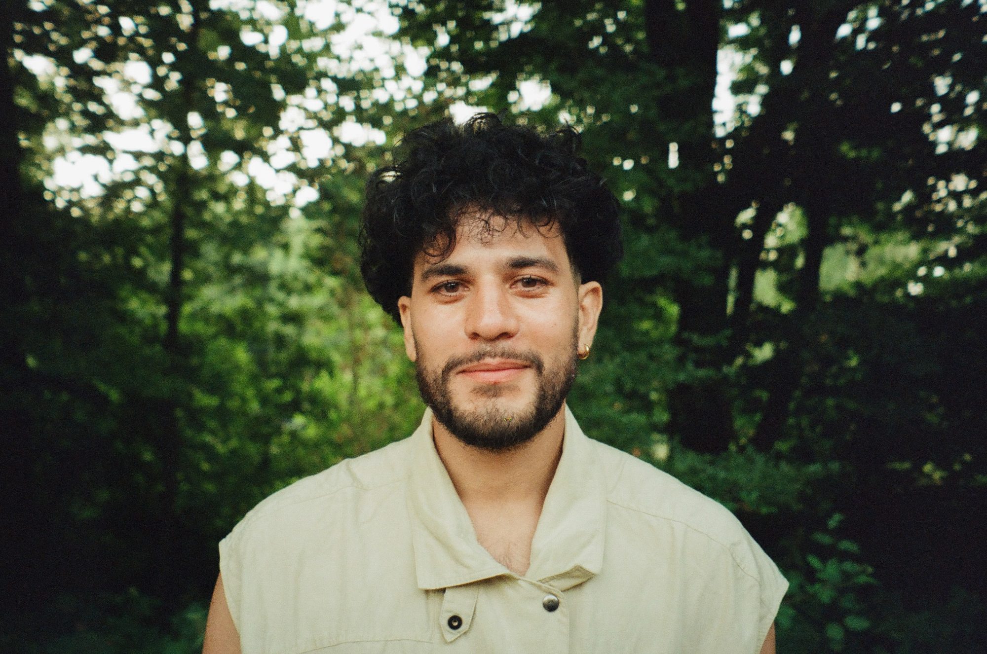 A portrait among the trees, in a pale collared shirt